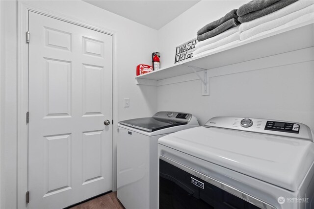 washroom with dark hardwood / wood-style floors and separate washer and dryer