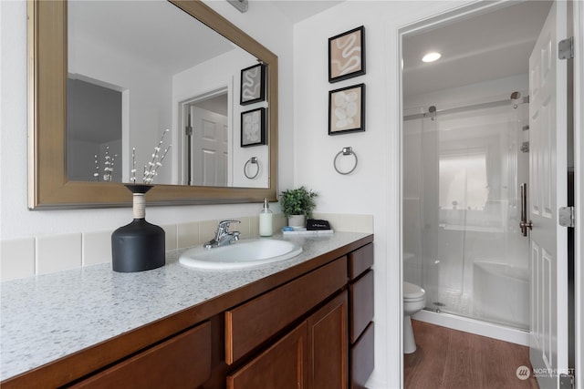 bathroom featuring vanity, hardwood / wood-style floors, an enclosed shower, and toilet