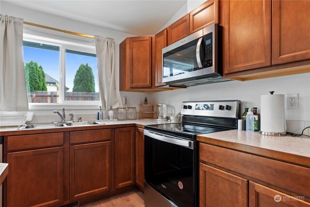 kitchen featuring sink, light hardwood / wood-style floors, and appliances with stainless steel finishes