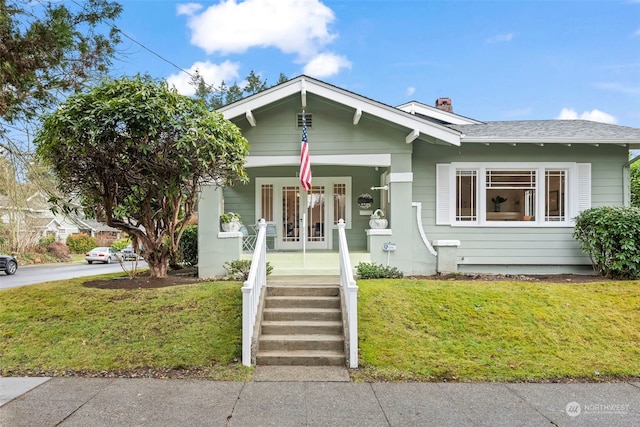 bungalow-style house featuring covered porch and a front lawn