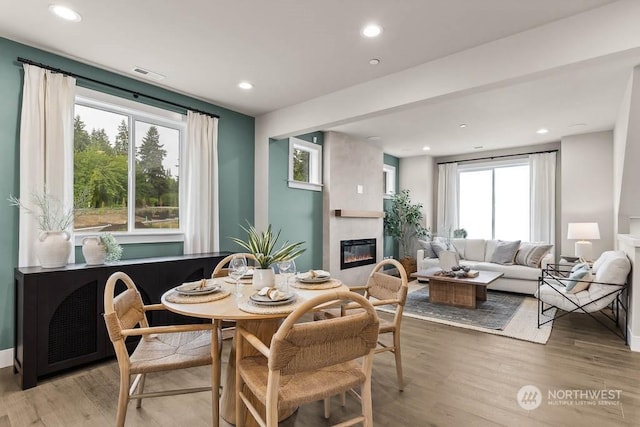 dining space featuring light wood-type flooring and a fireplace