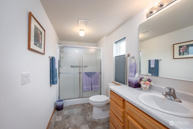 bathroom featuring vanity, toilet, and an enclosed shower