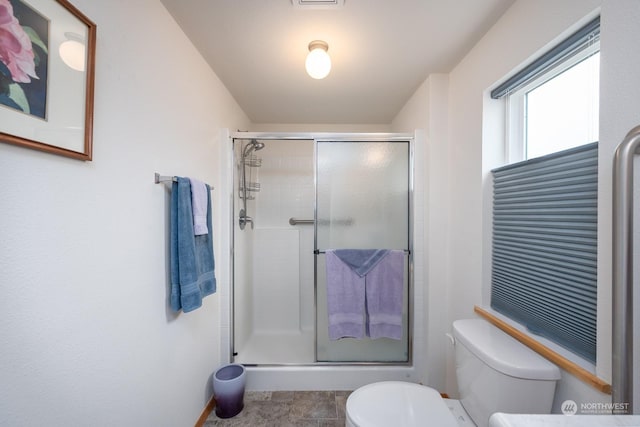 bathroom featuring walk in shower and toilet