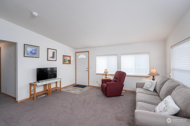 carpeted living room with a healthy amount of sunlight and vaulted ceiling