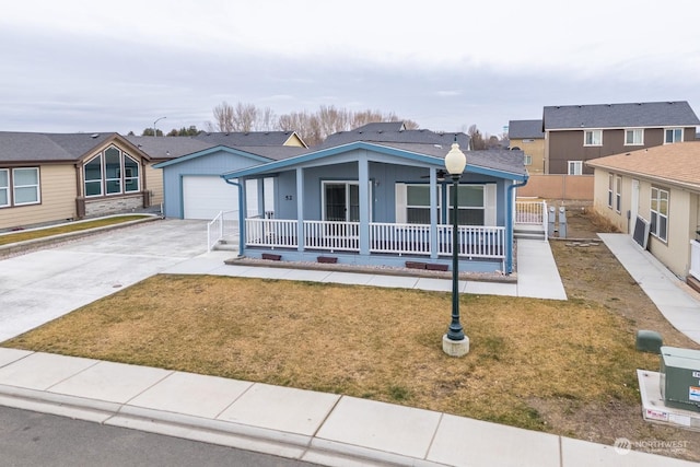 view of front of home featuring a garage, a front yard, and a porch