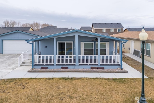 view of front of home featuring ceiling fan, a garage, covered porch, and a front yard