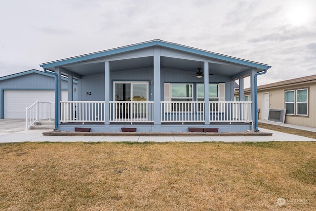 rear view of property with ceiling fan, a porch, a garage, and a lawn