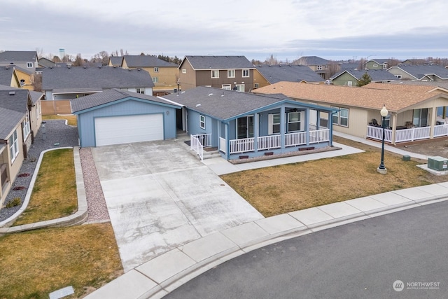 view of front of house with a garage, covered porch, and a front lawn