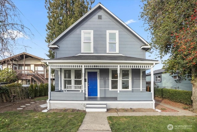 view of front of home with covered porch and a front lawn