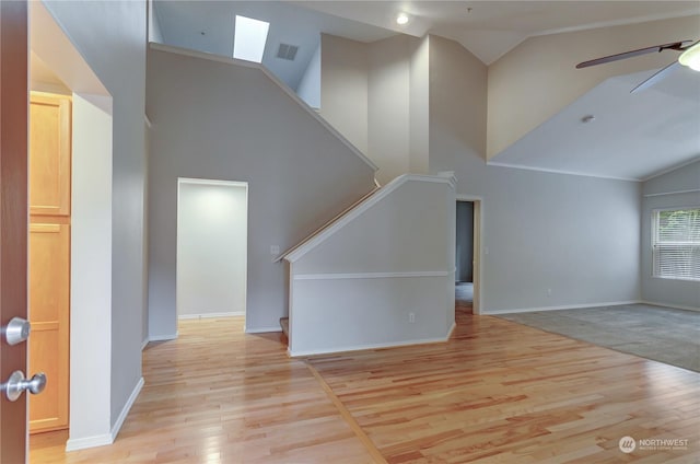 unfurnished living room with light hardwood / wood-style flooring, high vaulted ceiling, and ceiling fan