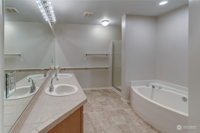 bathroom with vanity and shower with separate bathtub