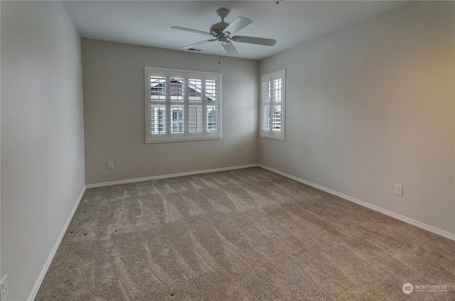 carpeted spare room featuring ceiling fan