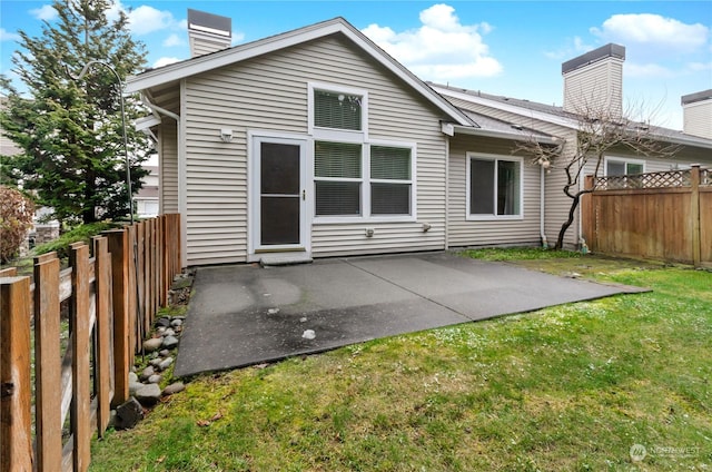 back of house featuring a patio and a lawn