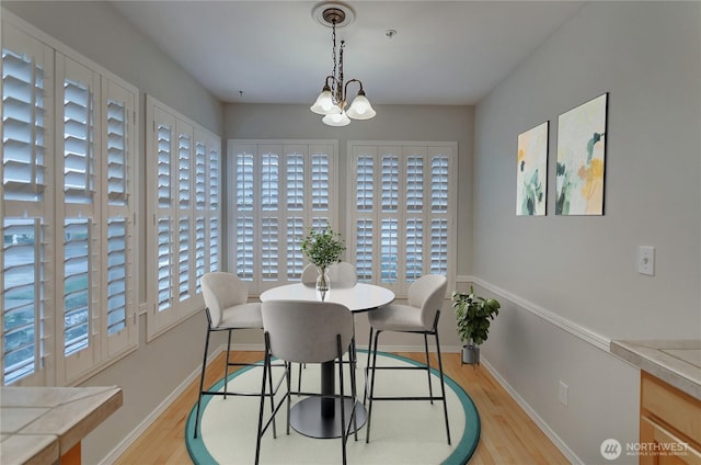 dining space featuring light hardwood / wood-style flooring and a notable chandelier