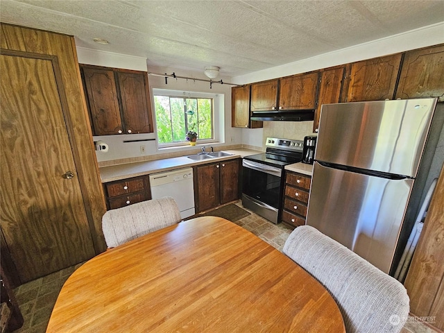 kitchen featuring stainless steel appliances, sink, and a textured ceiling