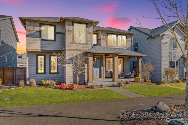 view of front of property with a porch and a yard