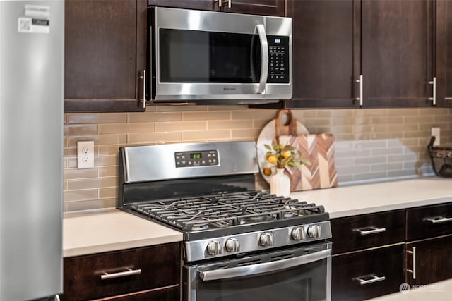 kitchen featuring dark brown cabinetry, stainless steel appliances, and backsplash