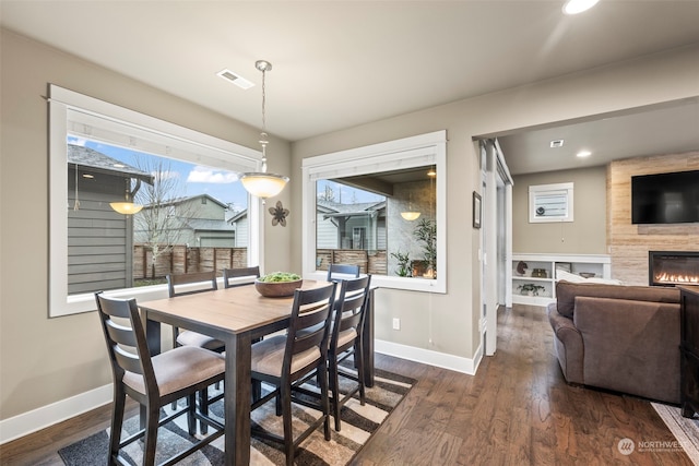 dining area with a fireplace and dark hardwood / wood-style floors