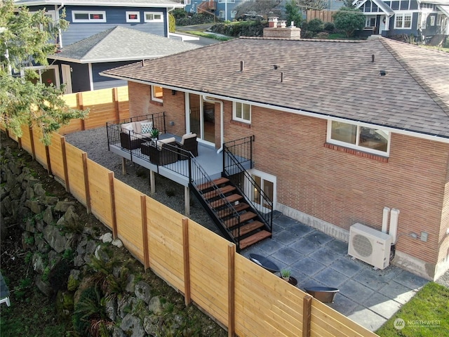 back of property featuring ac unit, brick siding, a shingled roof, outdoor lounge area, and stairs