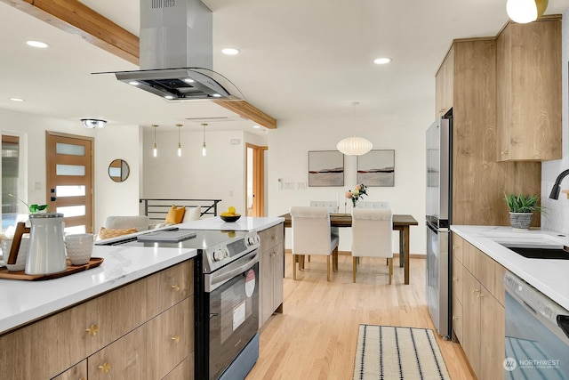 kitchen with pendant lighting, stainless steel appliances, light wood-style flooring, a sink, and island range hood