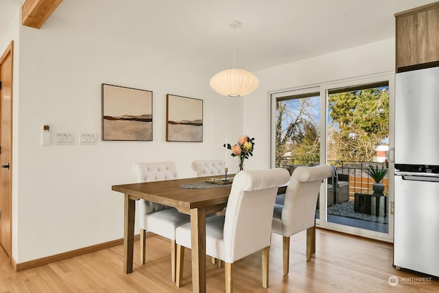 dining room featuring light wood finished floors and baseboards