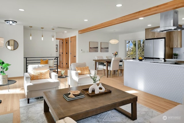 living area with light wood-type flooring, visible vents, beamed ceiling, and recessed lighting