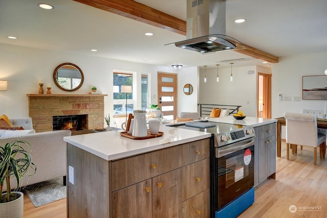 kitchen with stainless steel electric range oven, modern cabinets, open floor plan, a center island, and light countertops