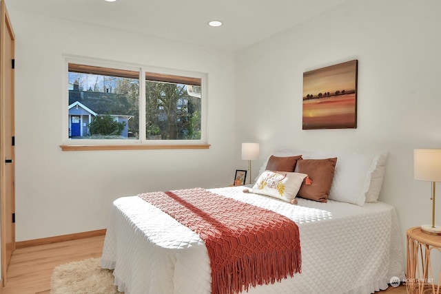 bedroom featuring recessed lighting, baseboards, multiple windows, and light wood finished floors