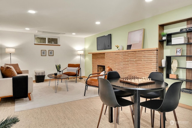 dining area with light colored carpet, recessed lighting, visible vents, baseboards, and a brick fireplace