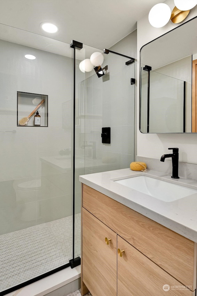 bathroom with a shower stall, vanity, and recessed lighting