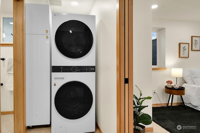 laundry room featuring light carpet, stacked washer and dryer, laundry area, baseboards, and recessed lighting