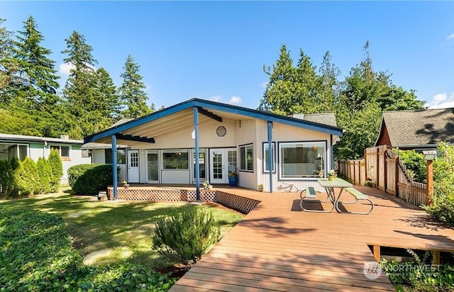 back of house with a wooden deck and a lawn