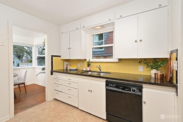 kitchen with white cabinetry, dishwasher, sink, dark stone countertops, and decorative backsplash