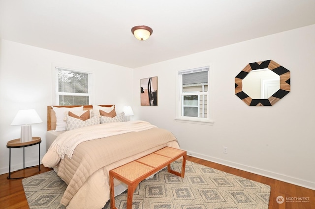 bedroom with hardwood / wood-style flooring and multiple windows