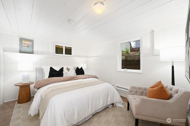 carpeted bedroom with wooden ceiling and a baseboard heating unit