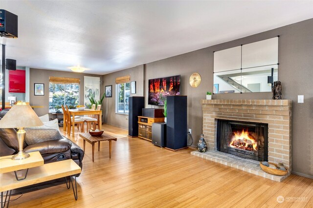 living room with hardwood / wood-style flooring and a brick fireplace