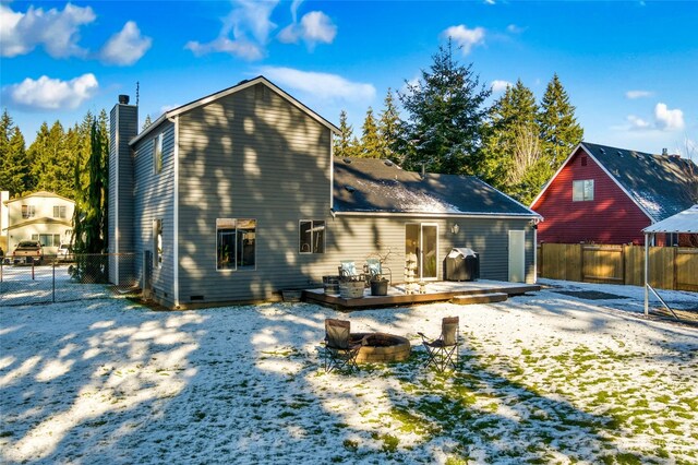 rear view of property with a wooden deck and a fire pit