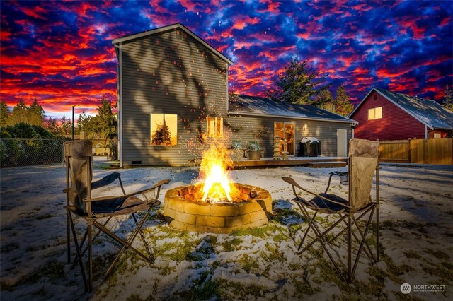 back house at dusk featuring an outdoor fire pit