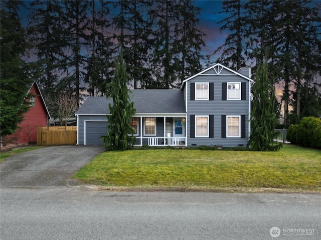 traditional-style home with aphalt driveway, a porch, an attached garage, a front yard, and fence