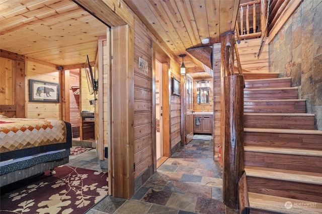 stairs featuring wood ceiling and wooden walls