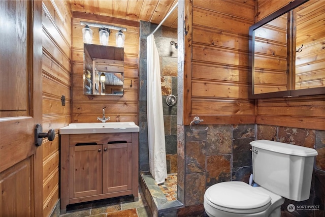 bathroom featuring vanity, curtained shower, toilet, and wood walls