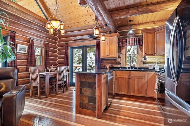 kitchen with sink, appliances with stainless steel finishes, hanging light fixtures, wood-type flooring, and french doors