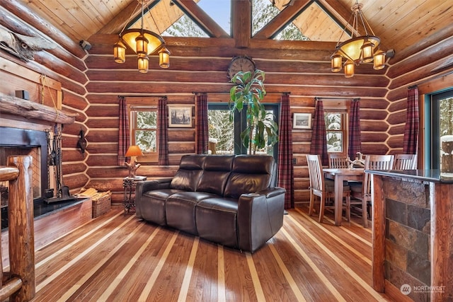 living room with wood-type flooring, high vaulted ceiling, a healthy amount of sunlight, and an inviting chandelier