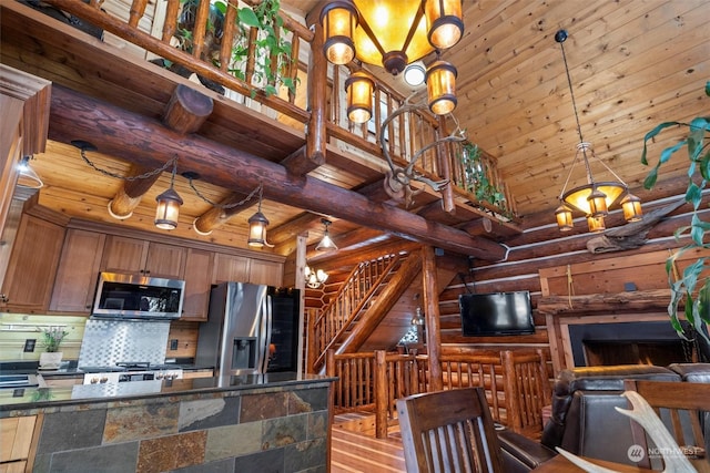 kitchen with wood ceiling, stainless steel appliances, high vaulted ceiling, and hanging light fixtures