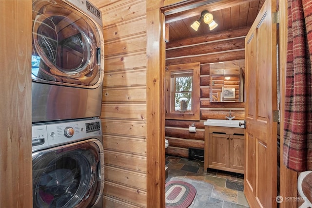 clothes washing area with stacked washer and clothes dryer, sink, and wooden ceiling