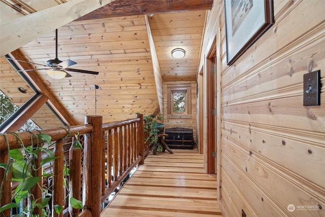 hall featuring wooden ceiling, wooden walls, and light hardwood / wood-style flooring