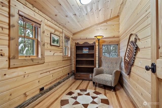 living area featuring hardwood / wood-style flooring, wooden ceiling, lofted ceiling, and wood walls