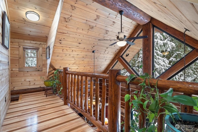 hall with lofted ceiling with beams, wooden ceiling, wooden walls, and light hardwood / wood-style flooring