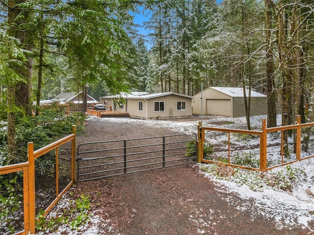 exterior space featuring a garage, an outdoor structure, and a deck