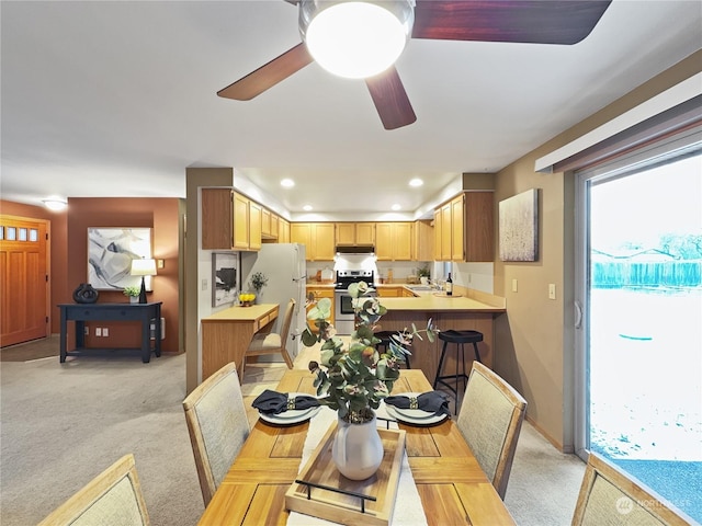 carpeted dining room featuring ceiling fan